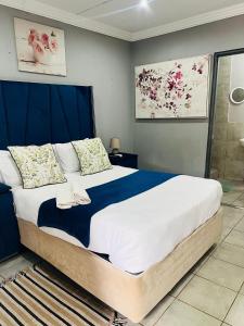 a bedroom with a large bed and a shower at Lugogo Guesthouse in Thohoyandou +36 photos