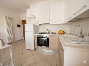 a kitchen with white cabinets and a stove and a sink at TRIESTE - Premium Villas in Giulianova