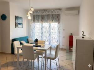 a living room with a table and chairs and a couch at TRIESTE - Premium Villas in Giulianova
