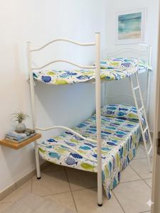 a bedroom with a bunk bed with a bedspread at TRIESTE - Premium Villas in Giulianova