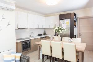 a kitchen with a wooden table and white cabinets at Villa Beta 2 - 3min walk to Elephant and Mako in Pefkochori