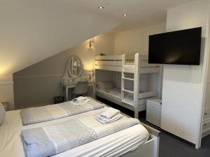 a bedroom with two bunk beds and a flat screen tv at Gästehaus Elzblick in Rust