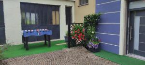 a house with a table and flowers next to a door at Apartments Giovannini in Fai della Paganella