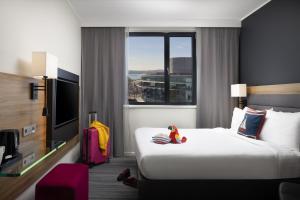 a hotel room with a bed and a large window at Moxy Southampton in Southampton