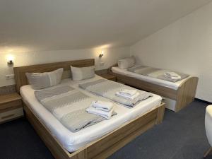 two beds in a room with towels on them at Gästehaus Elzblick in Rust +28 photos