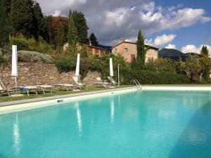 Una gran piscina azul con sillas y una casa. en La Vistosa, en Ciciana