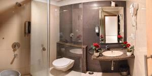 a bathroom with a toilet and a sink and a shower at Hotel Anantha Suites in Sitam Petta