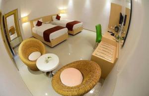 a room with two beds and a bathroom with a sink at Hotel Anantha Suites in Sitam Petta +16 photos