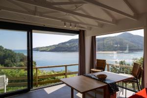 a room with a table and a view of the water at Bungalows Portuondo parking gratuito in Mundaka