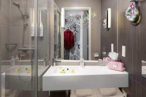 a bathroom with a white sink and a shower at Moxy Southampton in Southampton