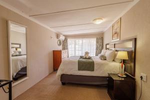 a bedroom with a large bed and a large window at Ulifalodge whitehouse in Hillcrest +47 photos