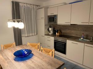 a kitchen with a wooden table with a blue bowl on it at "Am Yachthafen" in Seedorf