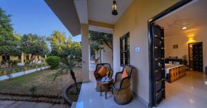 an open door to a room with a view of a garden at The Pugmark, A Wildlife Resort in Sawāi Mādhopur