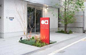 a red sign in front of a building at Apartment Hotel UCHIWA STAY Osaka NAMBA in Osaka
