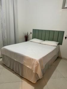 a bed with a green headboard in a room at Casa Verano dHebron in Camaçari +8 photos