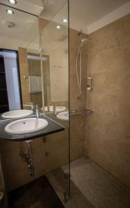 a bathroom with two sinks and a glass shower at Gästehaus am Räuschenberg in Höxter