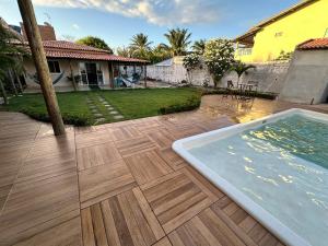 a backyard with a swimming pool and a house at Casa Verano dHebron in Camaçari