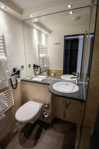 a bathroom with a toilet and a sink and a mirror at Gästehaus am Räuschenberg in Höxter