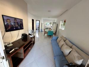 a living room with a blue couch and a tv at Casa Verano dHebron in Camaçari