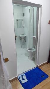 a bathroom with a toilet and a blue rug at Marine waters retreat Block A in Embu +32 photos