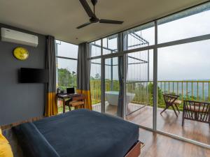 a bedroom with a bed and a view of a balcony at The Hosteller Bam Vagamon in Vagamon