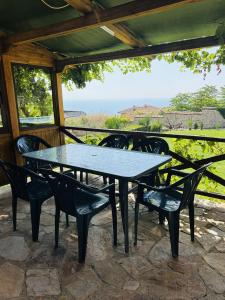 a table and chairs on a patio with a view of the ocean at Heaven's Home in Topola