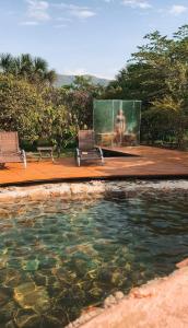 a pool of water with two chairs and a screen at Pousada Cajuzinho do Cerrado in Cavalcante
