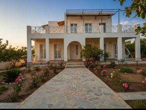 a large house with a walkway in front of it at MOSXONAS House in Áyioi Asómatoi