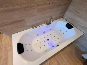 a white bath tub in a bathroom with wooden floors at Le Loft des Crêtes in Dinant +39 photos