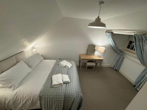 a bedroom with a bed with two towels on it at St Giles Lodge in Inverness