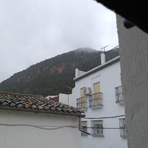 a white building with a mountain in the background at Casa Lolo in Algodonales