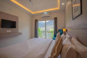 a bedroom with a bed with a television and a window at Alpine Retreat in Narendranagar