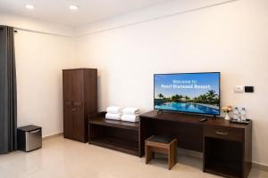 a hotel room with a flat screen tv on a wall at Pearl Diamond Resort in Trincomalee