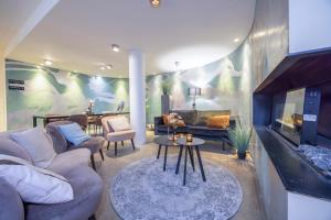 ein Wohnzimmer mit Sofa und Kamin in der Unterkunft Fletcher Hotel - Restaurant Elzenduin in Ter Heijde
