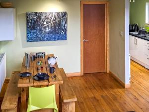a kitchen with a wooden table and green chairs at Mercury 5 - Uk50475 in Greenhaugh