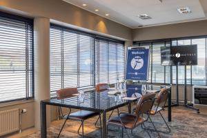 ein Konferenzraum mit Tisch, Stühlen und Bildschirm in der Unterkunft Fletcher Hotel - Restaurant Elzenduin in Ter Heijde