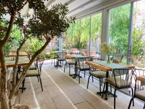 a room with tables and chairs and windows at Cunda ILIOS in Ayvalık