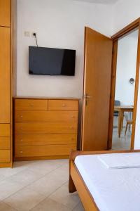 a bedroom with a bed and a tv on a wall at Irene Apartment in Kardamaina