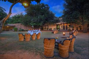 a group of people sitting in chairs in a yard at The Pugmark, A Wildlife Resort in Sawāi Mādhopur
