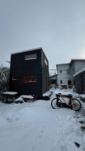 a bike parked in the snow in front of a building at Stone Tiny Chalten Nordic Cabin Patagonia - Arg in El Chalten +4 photos