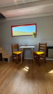 a room with two benches and a table and a window at Stone Tiny Chalten Nordic Cabin Patagonia - Arg in El Chalten