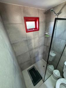a bathroom with a shower and a toilet and a window at Stone Tiny Chalten Nordic Cabin Patagonia - Arg in El Chalten