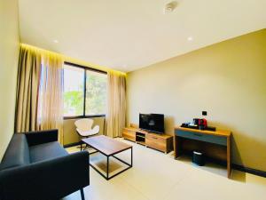 a living room with a couch and a tv at New Amaan Hotel in Zanzibar City
