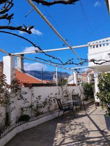 a patio with two chairs and a table on a white wall at Guest House LEA in Mostar