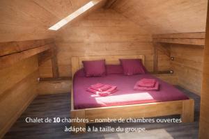 a bed in a wooden room with two pink towels on it at Domusigua in Gérardmer +22 photos