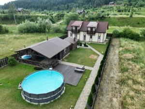 an aerial view of a house with a swimming pool at Котедж "Під Горбком" in Korchin