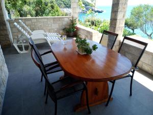 a wooden table and chairs on a patio with the ocean at Contessa robinson house in Korčula +59 photos