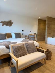 a bedroom with a large bed with a bench in it at Le Loft des Crêtes in Dinant