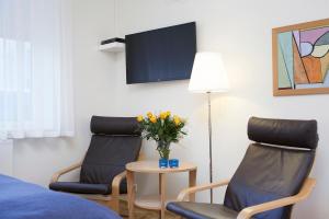 een kamer met 2 stoelen en een tafel met een vaas met bloemen bij Northern Comfort Apartments in Reykjavík