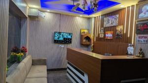 a bar with a couch and a tv in a room at Hotel Kaushik Palace in Haridwār
